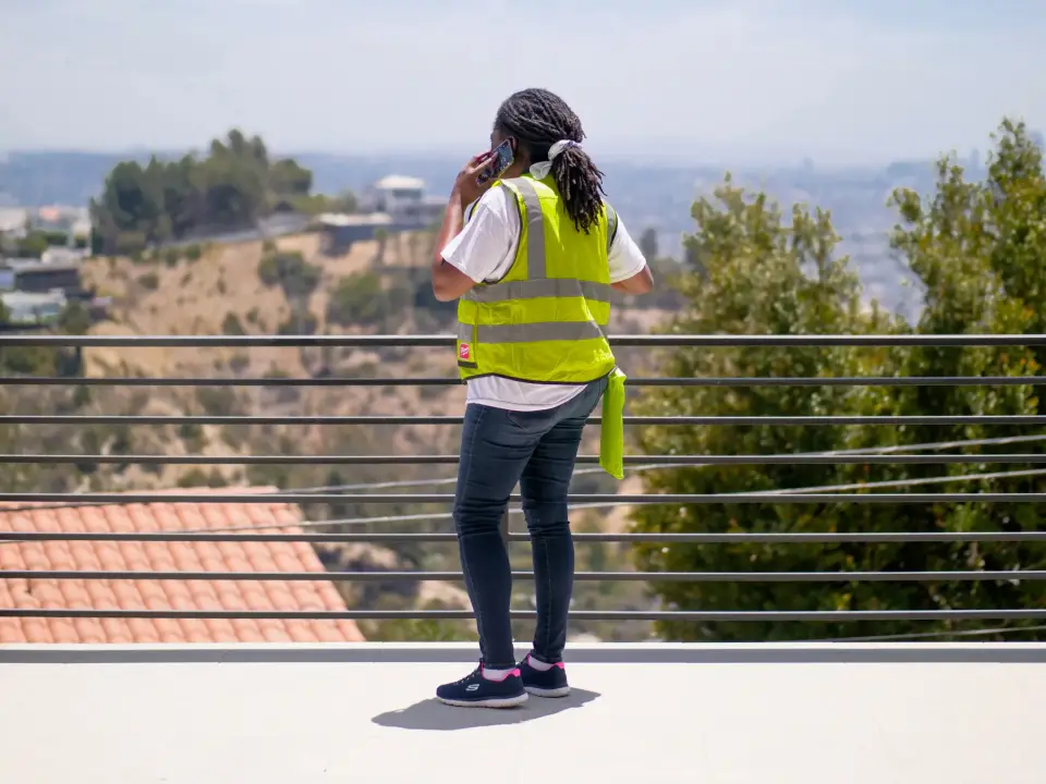 Une travailleuse appelle un agent IA depuis un chantier