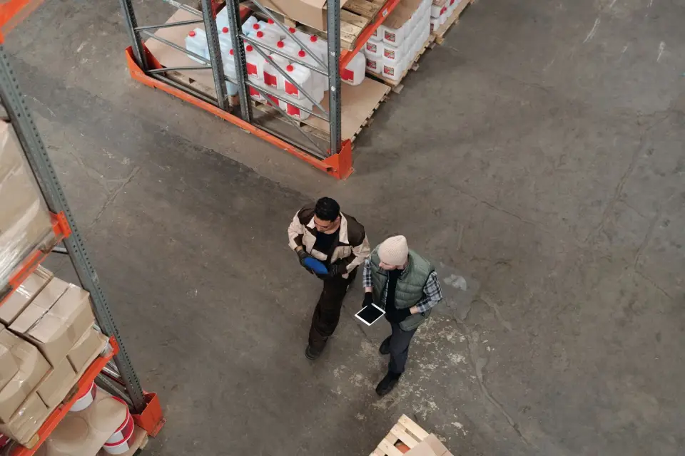 Deux employés coordonnent l’inventaire avec une tablette dans un entrepôt